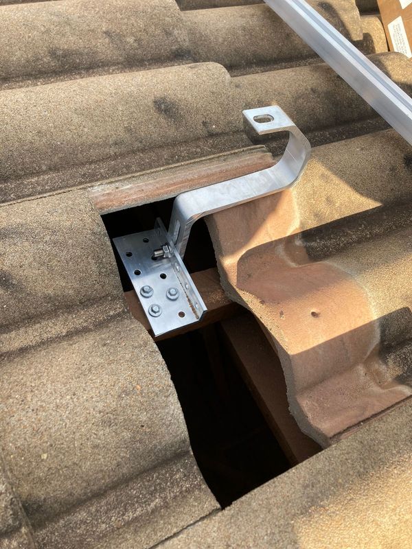 Installed aluminum hook under a roof tile
